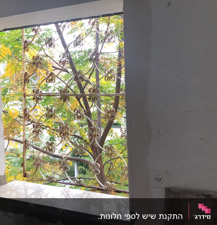 משטח שיש על אדן חלון עם סורגי ברזל